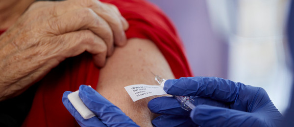 En person får en spruta med vaccin mot Covid-19.